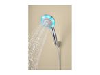 Chrome shower head with blue LED lights spraying water against a beige wall.