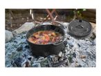 Dutch oven with seafood stew cooking over hot coals outdoors.