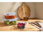 Recipiente de sticlă Silvercrest® cu salată, sos și fructe de pădure pe o masă de lemn.