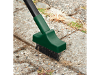 Weed brush with a dark green head and black bristles cleaning between paving stones.
