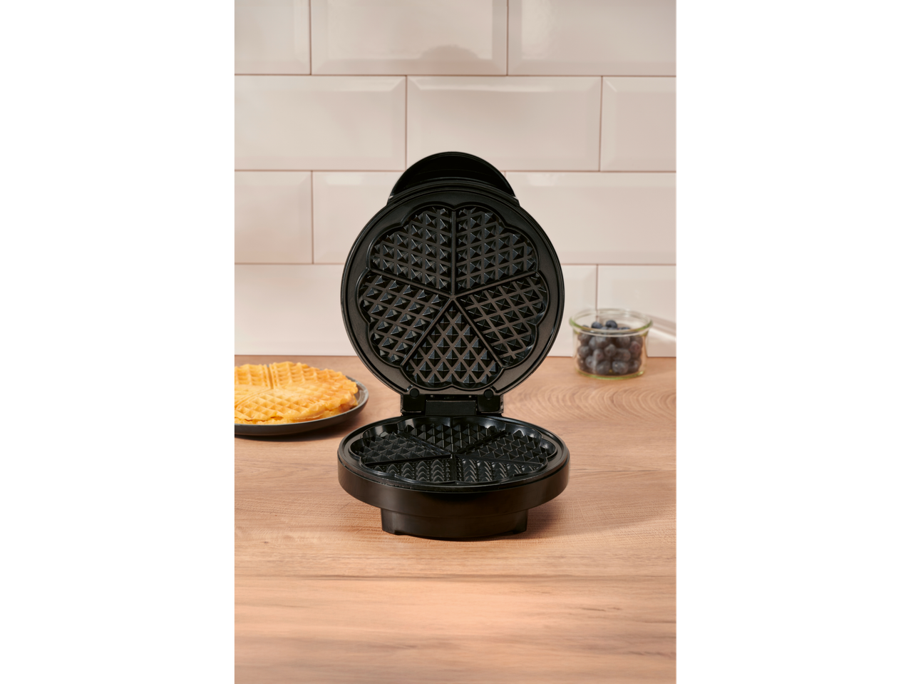 SILVERCREST waffle maker, open, with waffles and blueberries on a wooden counter.