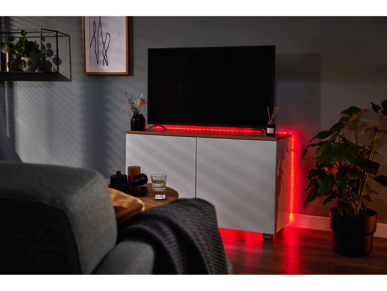 Iluminare LED roșie în spatele unui televizor și a unui dulap.
