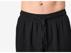 Pantaloni de pijama negri din muselină ESMARA cu șnur, pe torsul unui bărbat.