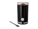 Black electric coffee grinder with ground coffee inside and a cleaning brush.