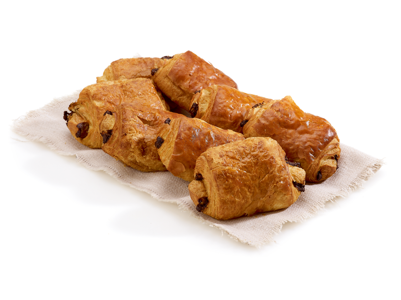 Plusieurs pains au chocolat dorés sur un morceau de tissu en lin.