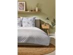 Bed with quilt and pillows in a floral design.