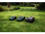 Three PARKSIDE® 20V Robot Lawn Mowers, two green and one black, on a lush lawn.