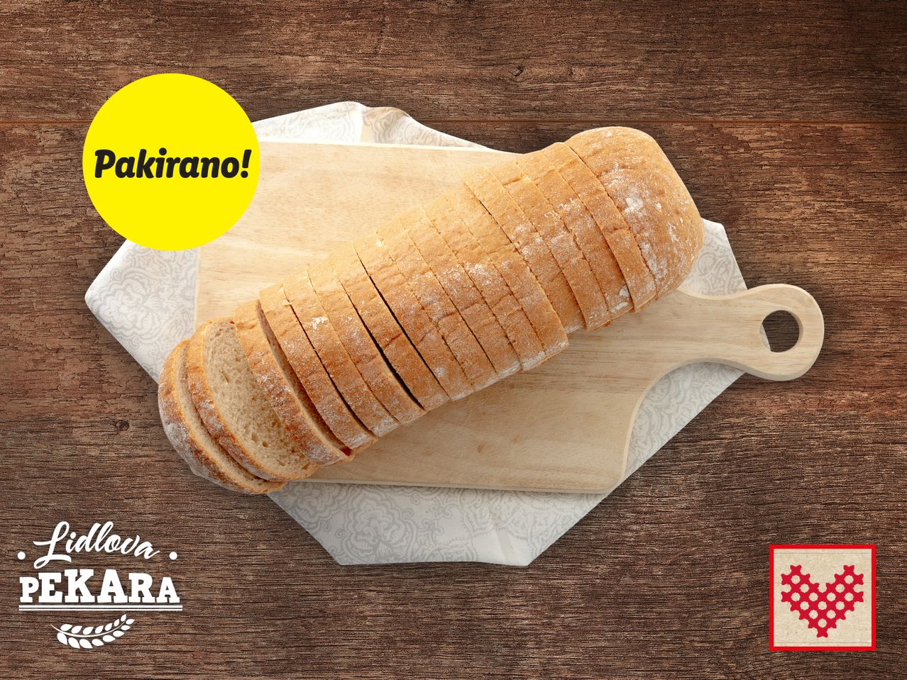 Polukružni kruh Pakračan, narezan na kriške, na bijelom drvenom stalku.
