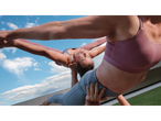Mulheres em tops desportivos e leggings CRIVIT, praticando acroyoga ao ar livre.