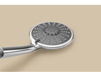 Close-up of a modern chrome shower head with a gray spray face and multiple settings.