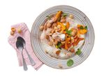 Dessert with whipped cream, sliced apricots, amaretti biscuits, and mint on a striped plate.