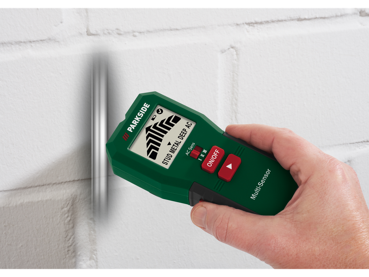 Parkside® višenamjenski detektor korišten na bijelom zidu, detektira cijev.