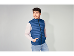 Homem com colete acolchoado azul Livergy e calças de ganga claras.