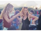 Femei dansând la un festival de muzică vara, în rochii și stiluri boho-chic.