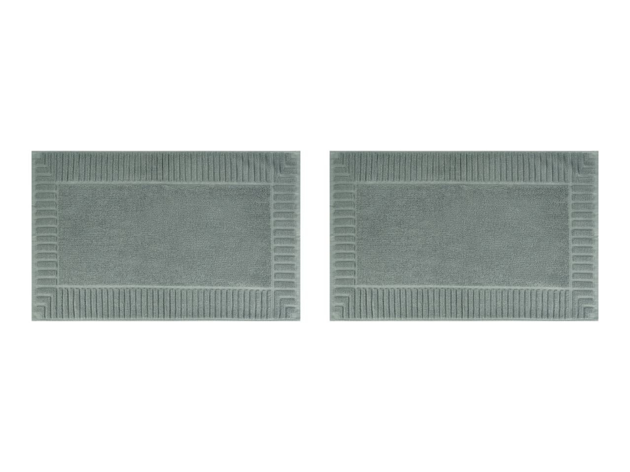 Two rectangular light green bath mats with a textured border design.