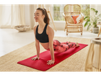 Femeie făcând yoga în poziția de cobra pe un covor roșu.