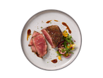 Bife de lombo com salada de manga e cebola roxa num prato cinzento.