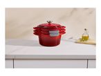 Red cast iron pots stacked on a white kitchen counter with olive oil and rosemary.