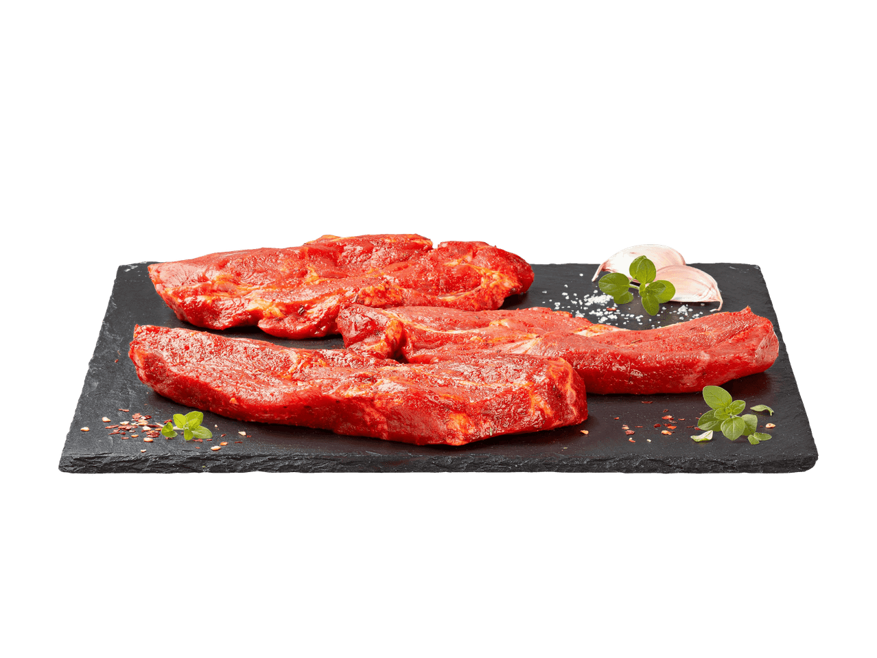 Mariniertes Fleisch auf einem Schieferbrett mit Knoblauch, Salz und Oregano.