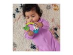 Baby in a purple sleepsuit lying on a patterned rug, holding a colorful sloth-themed teether.