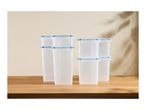A set of clear plastic food storage containers with blue lids on a wooden table