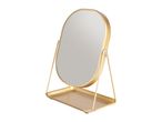 Gold oval vanity mirror with a tray base on a white background.