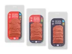 Tre pakker let røget laksesashimi, to med sød chili og en almindelig, med en 'Ny' etiket.