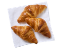 Três croissants de manteiga dourados sobre um guardanapo branco
