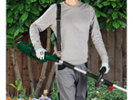 Um homem segura um aparador de grama Einhell verde sem fio.