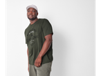 Un bărbat poartă un tricou verde-oliv cu imprimeu și o șapcă de baseball.