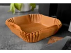 Forros de papel quadrados para fritadeira de ar quente sobre uma superfície cinzenta.