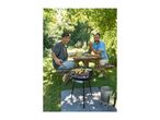 Two men grilling vegetable skewers on a barbecue in a garden.