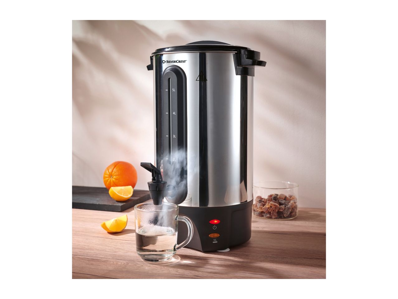 SilverCrest hot water dispenser with oranges and rock sugar on a wooden table.