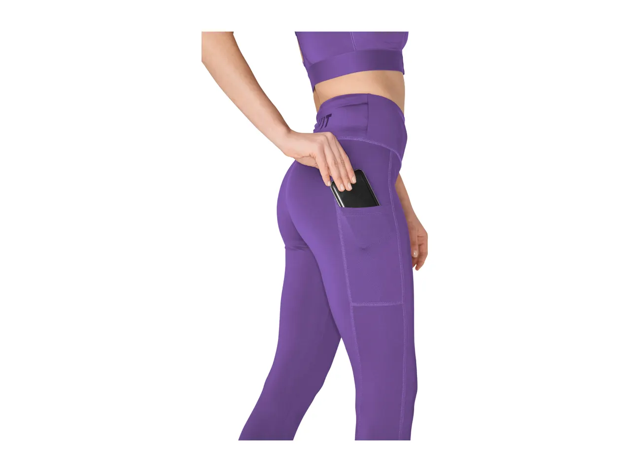 Woman in purple sports bra and leggings with a phone in the side pocket.