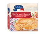 Løg quiche med bacon i en papemballage, klar til ovn.