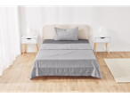 Bedroom with light wood flooring, white nightstands, and gray patterned bedding.