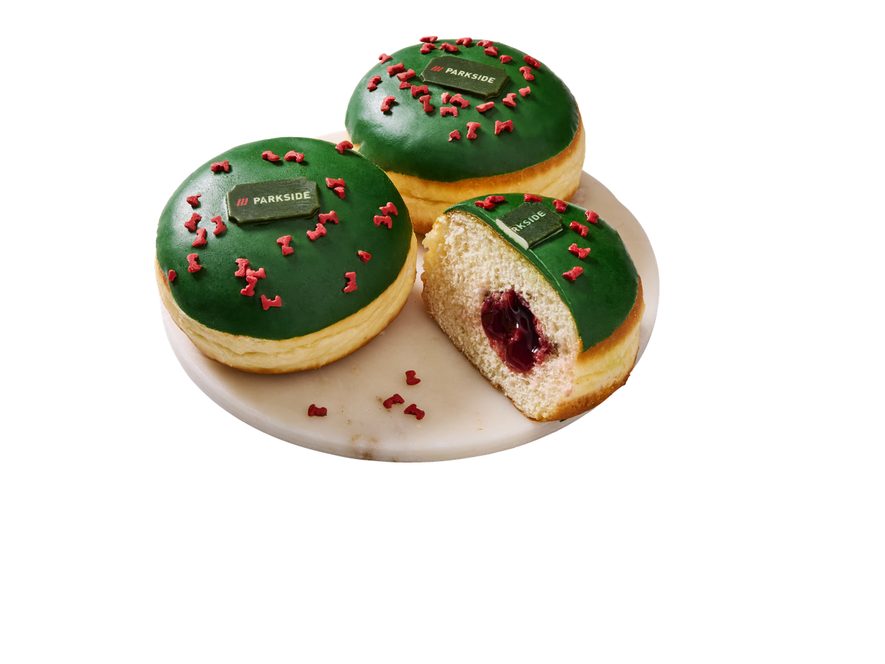 Groen geglazuurde Parkside-donuts met rode hagelslag en bessenvulling, op een wit bord.