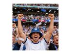 Excited fan in a blue bucket hat cheering at a sports event with confetti falling.