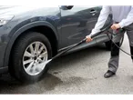 A person cleans a car with a Parkside® pressure washer.