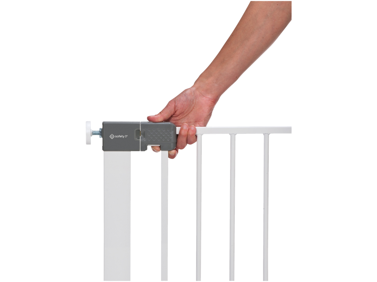 A hand holding the top bar of a white baby safety gate with a grey locking mechanism.