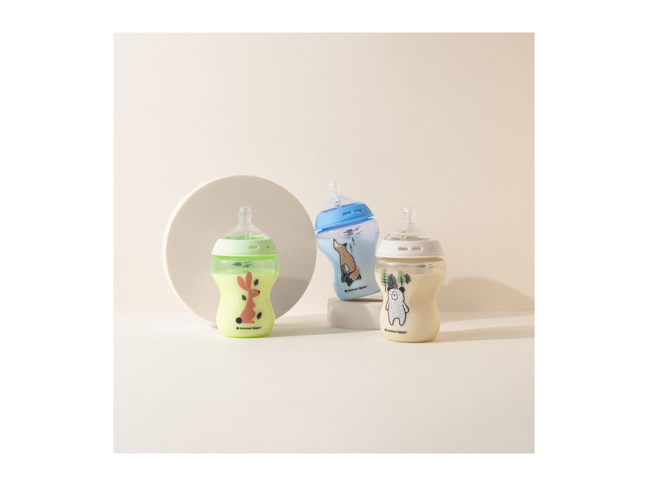 Three Tommee Tippee baby bottles with animal designs on a light background.