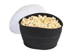 Black popcorn bowl filled with popcorn, with a clear lid resting beside it.