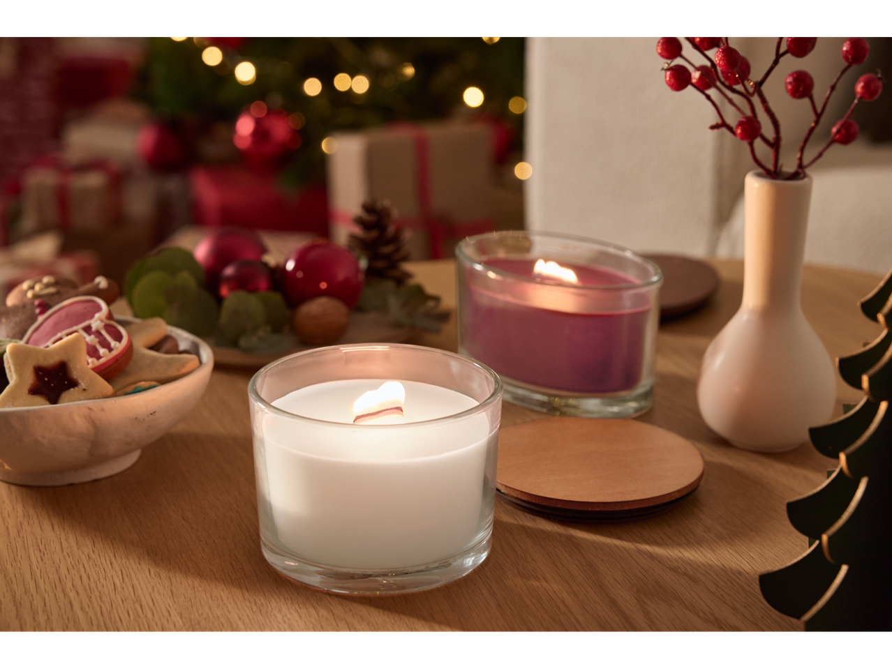 LIVARNO home Scented Candles, Christmas decorations, and cookies on a wooden table.