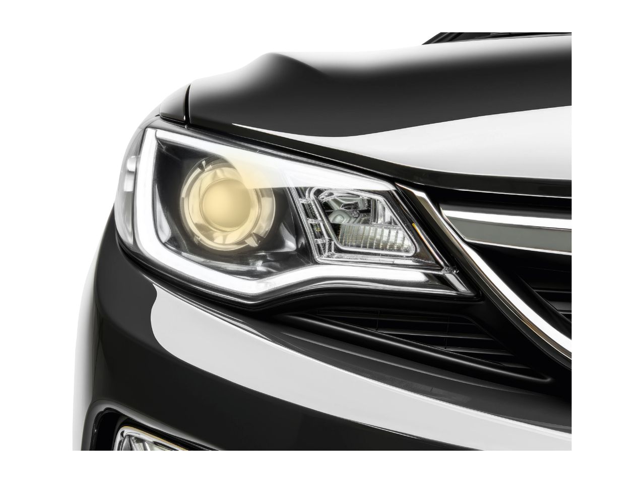 Close-up of a black car's headlight with a yellow beam and LED daytime running lights