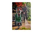 A man pressure washing a patio with a green and black pressure washer.