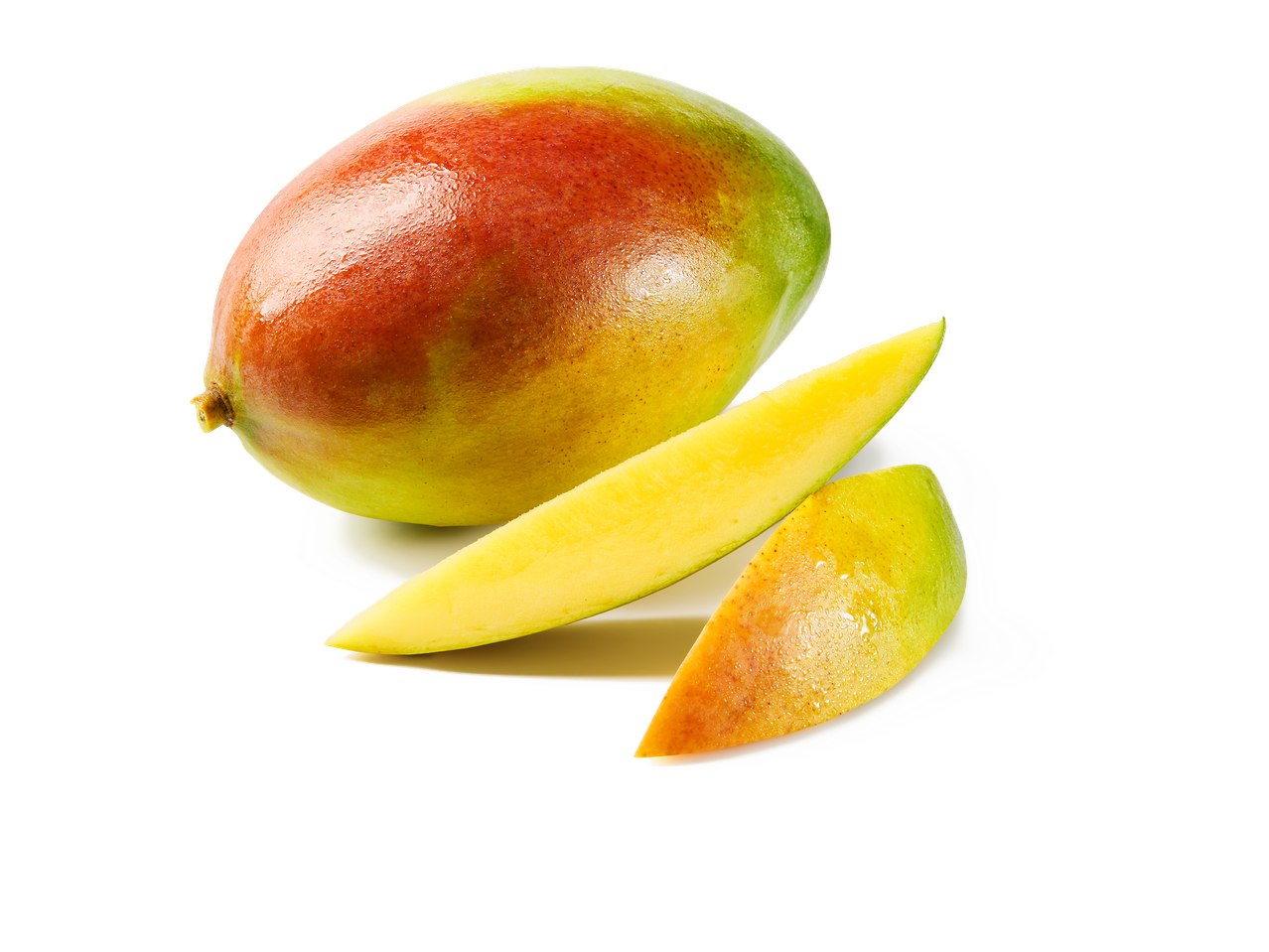 Mangue entière et deux tranches de mangue fraîche sur fond noir.