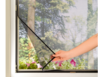 LIVARNO Plasa anti-insecte pentru fereastră, o mână ajustând plasa neagră cu vedere la o grădină verde.