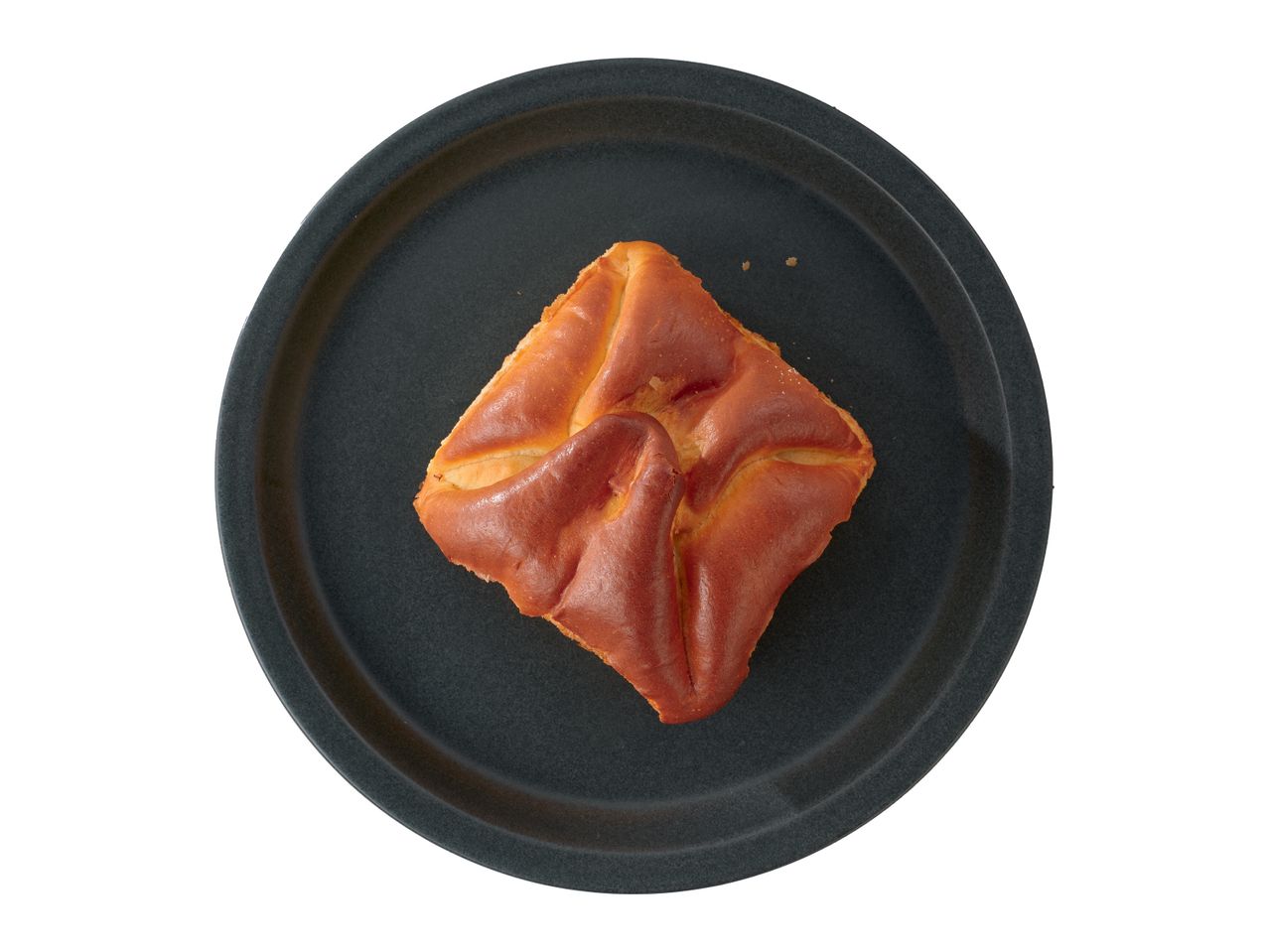 O patiserie pătrată, aurie, pe o farfurie rotundă, gri închis.