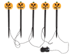 Öt darabos, tök alakú, leszúrható halloweeni LED-es kerti lámpa fekete háttér előtt.