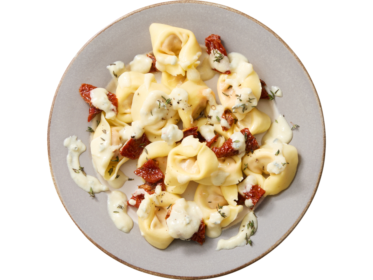 Tortellini met blauwschimmelkaas saus en gedroogde tomaten op een bord.
